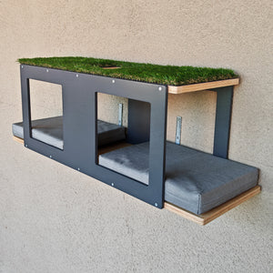 Catio shelf for large cats. Made for mounting on steel mesh or on wooden or metal beams. It has multiple entry points and 4 large windows. The fronts and back(accents) are in dark grey, and the base wood is in natural birch. There are two large grey cushions on the bottom larger shelf. The top has an opening in the middle and is carpeted with artificial grass. It comes fully assembled and ready for installation. Mounting hardware is included. 
